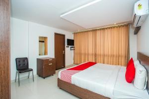 a bedroom with a bed and a desk and a chair at Hotel O Corner Golf View Near Embassy Golf Link Business Park in Bengaluru +36 photos