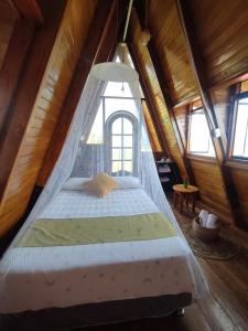 a bed in a wooden room with a window at Casa Alpina - Barlovento Ecolodge Tarapoto - Matrimonial in Tarapoto
