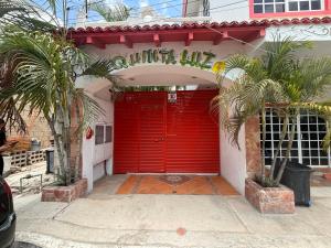 トゥルムにあるQuinta Luzのヤシの木のある建物の赤いガレージのドア