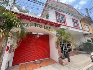 トゥルムにあるQuinta Luzのヤシの木のある家の赤いガレージのドア