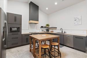 a kitchen with a wooden table and a refrigerator at Vienna's Modern Retreat in Rapid City +19 photos