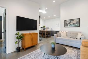 Una sala de estar con un sofá y un televisor en una pared. en Vienna's Modern Retreat, en Rapid City