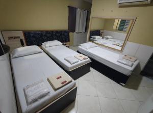 a room with three beds and a mirror at Hotel Flert Santana in Sao Paulo +5 photos