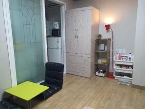 un salon avec une table jaune et une chaise dans l'établissement Daegu Little House, à Daegu
