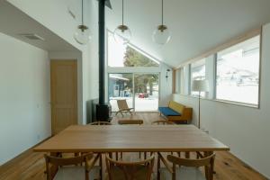 a dining room with a wooden table and chairs at JOKIJOKI Hakuba in Hakuba