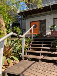 a set of stairs leading to a building with an orange door at Tranquil Garden Apartment with living room in Wollongong