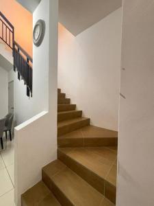 a staircase in a house with a clock on the wall at Hz homestay in Simpang Ampat