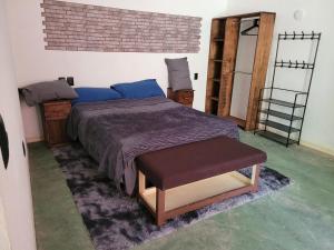 a bedroom with a bed with a purple blanket and a stool at Departamento Miguel Angel in Oaxaca City