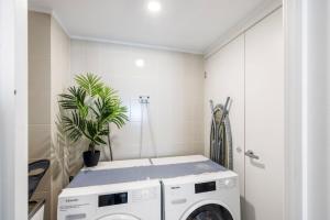 una lavanderia bianca con lavatrice di Lanimer ONE - Beautiful Waterfront Property a Soldiers Point