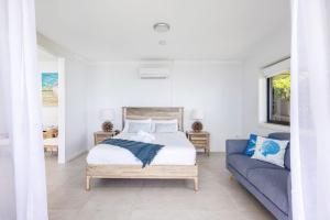 una camera da letto con un letto e un divano di Lanimer ONE - Beautiful Waterfront Property a Soldiers Point