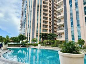 een zwembad voor een groot gebouw bij Cozy home Near NAIA & BGC in Manilla