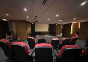 een vergaderzaal met rode stoelen en een podium bij Cozy home Near NAIA & BGC in Manilla +25 foto's