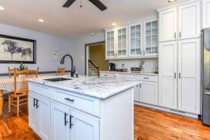 a kitchen with white cabinets and a kitchen island at Villa on a hill with indoor heated salt water pool in Boyertown