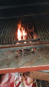 a grill with a fire in the middle of it at Mi Refugio Cabaña in Tigre