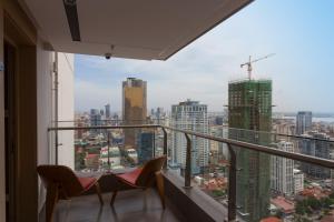 a balcony with two chairs and a view of a city at Cityscape Haven in Phnom Penh