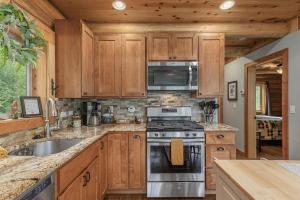a kitchen with wooden cabinets and a stove top oven at Bearfoot Chalet by NW Comfy Cabins in Leavenworth