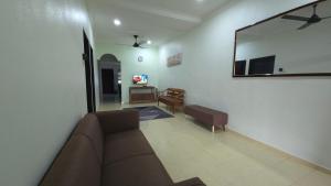 a living room with a couch and a mirror at Rasha Homestay in Tanah Merah