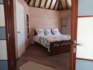 a small bedroom with a bed in a room at Fare Mama Fenua plage baleines Moorea Temae in Teavaro