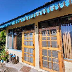 een huis met houten deuren en ramen bij Basanti Rawat Homestay in Munsyari