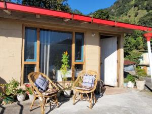 twee rieten stoelen voor een gebouw bij Basanti Rawat Homestay in Munsyari +38 foto's