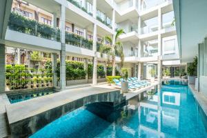 an exterior view of a building with a swimming pool at AQ-VA Hotel & Villas Seminyak in Legian