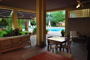 a dining room with a table and chairs and a pool at Palm Court Suites in Ayvalık +47 photos