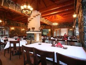 a restaurant with a large white table and chairs at Ta Skalopatia in Palaios Agios Athanasios