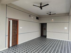 an empty room with a ceiling fan and a door at SHIVADIVYA Homestay Hampi in Hampi +2 photos