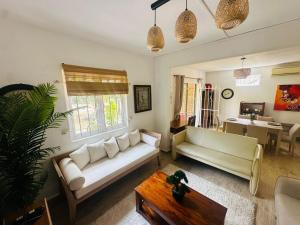a living room with a couch and a table at Sands Beach Villa Flic en Flac in Flic-en-Flac