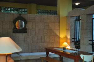 a living room with a table and a mirror at Palm Court Suites in Ayvalık