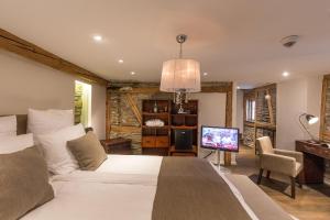 a bedroom with a bed and a television in it at Boutique - Hotel Adara in Lindau