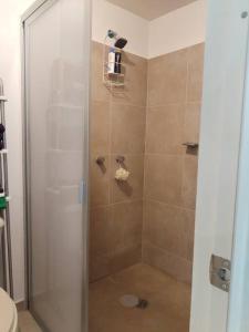a shower with a glass door in a bathroom at Departamento en pueblan puebla colonial in El Gallinero