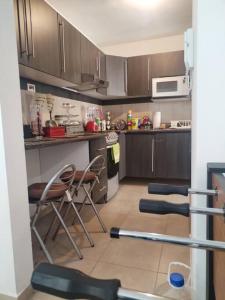 a kitchen with brown cabinets and chairs in it at Departamento en pueblan puebla colonial in El Gallinero