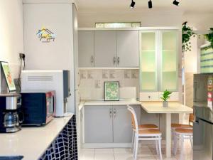 a kitchen with white cabinets and a table at 8pax3minsdrivetoJonkerTownArea in Melaka +27 photos