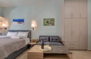 a bedroom with a bed and a couch and a table at ST Studio in Preveza