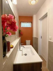 a bathroom with a sink and a vase of flowers at Taapuna SunSet Moorea View in Atiue