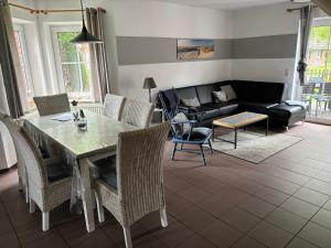a living room with a table and chairs and a couch at Ferienhaus Heimathafen Neßmersiel in Neßmersiel