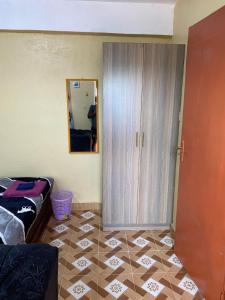 a room with a closet and a tiled floor at Tsavo Apartments Ogembo Single Room in Ogembo