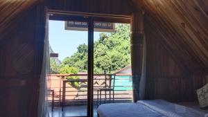a bedroom with a window with a view of a balcony at Amphai Guest house in Nongkhiaw