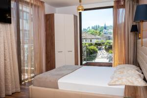 a bedroom with a bed and a large window at Enika Hotel in Tryavna