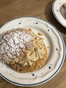 a pastry on a plate with powdered sugar on it at Maison d'hôtes Larraldia in Uhart-Cize