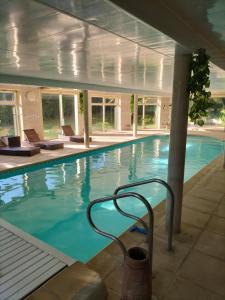 弗尔黎祖Au Charme du Lac Espace bien être et Piscine chauffé proche parc et restaurant du casino的建筑物内设有带椅子的大型游泳池