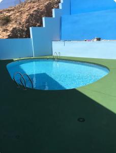 a large swimming pool with a blue wall and stairs at Vistas al mar in Carboneras