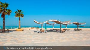 a pavilion with tables and chairs on the beach at Grand Cosmopolitan Hotel in Dubai