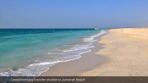 a sandy beach with the ocean in the background at Grand Cosmopolitan Hotel in Dubai