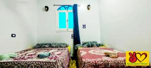 una camera con due letti e una finestra di Kayan Guest House a Aswan