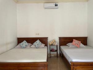 Dos camas una al lado de la otra en una habitación. en Pondok Linda, en Gili Trawangan