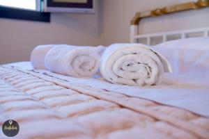 a stack of towels on top of a bed at Seaside Apartments in Emporeios