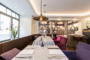 a restaurant with a long table with wine glasses at Boutique - Hotel Adara in Lindau