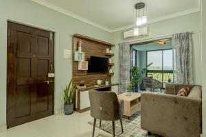 un salon avec un canapé et une télévision dans l'établissement Idyllic Abode 2 bhk apartment, à Goa